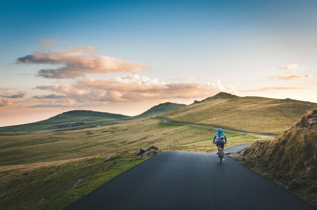 Woman cycling on urban trail during sunset for cycling weight loss